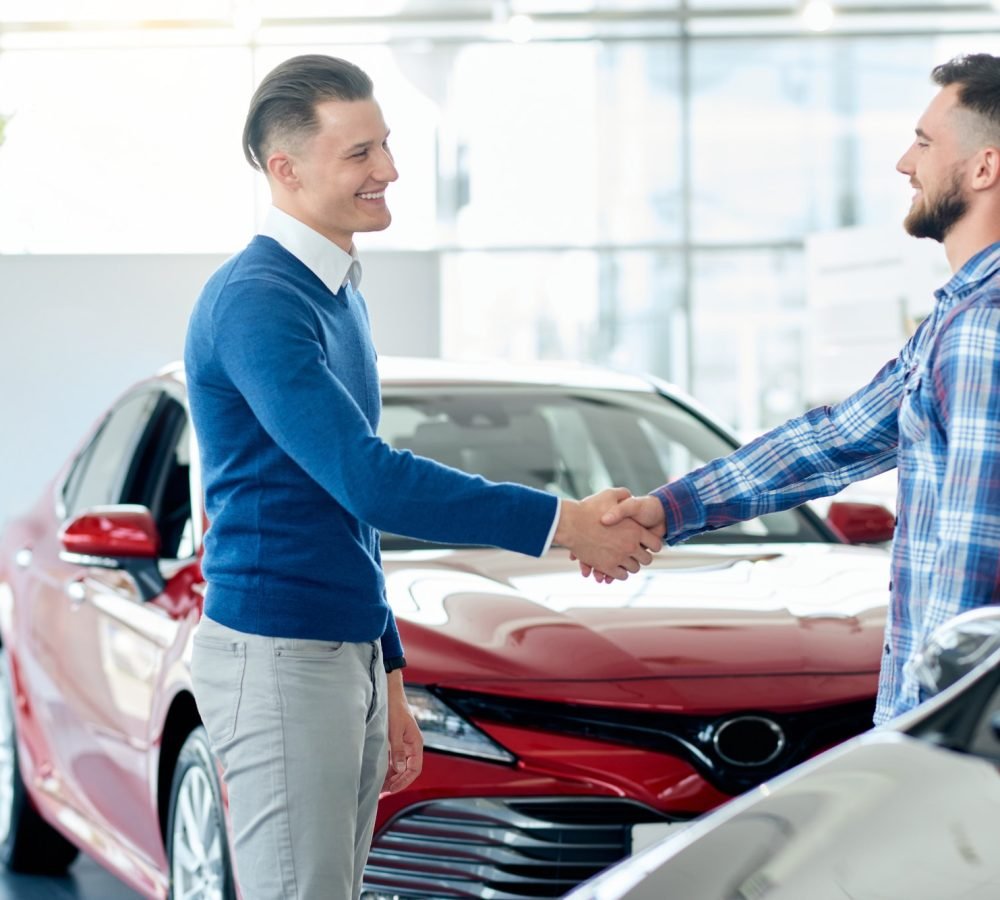 car-seller-and-customer-handshake-in-car-dealership.jpg